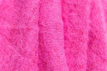 Pattern of pink knitted sweater  closeup. A stack of folded clothes