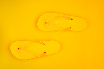 Trendy sunlight Summer composition. Beach flip-flops on a yellow background. Minimal summer concept.