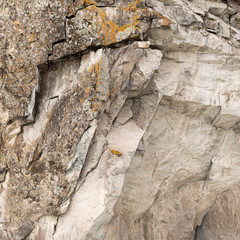 stone wall of cliff with cobblestones and clay