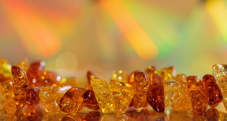 Amber beads on a colored background. Decoration, copy space. Rainbow, macro.