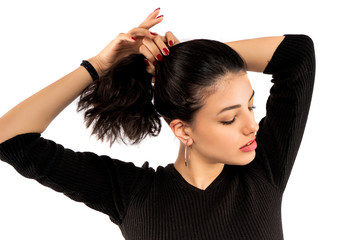 Brunette girl holding her black hair isolated on white background. Portrait of beauty girl.