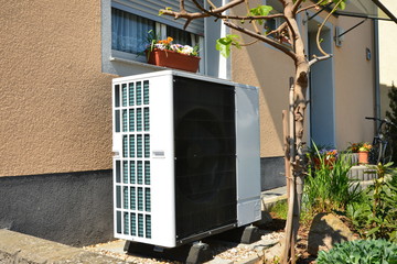 Klimaanlage/Luftwärmepumpe für Heizung und Warmwasser vor einem Einfamilienhaus