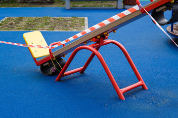 Children's playground in the city fenced with a signal red and white ribbon during the prom pandemic of coronavirus covid-19