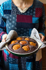 Woman hold chocolate baked apple, fruit and nuts brownie. Sweet vegan brown dessert cake, pie. Breakfast