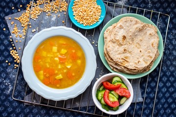 Lentil peas soup with vegetables, flatbread tortilla or chapati bread, fresh salad. Vegan healthy lunch food. Overhead