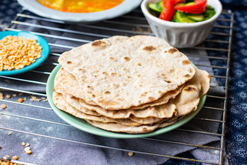 Plain chapati or tortillas flatbread. Naan bread. Vegan food. Woman hands