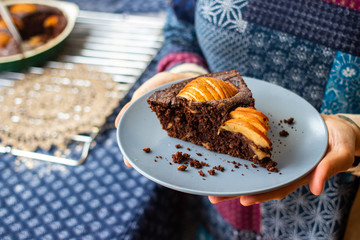 A piece of chocolate baked apple, fruit and nuts brownie. Sweet vegan brown dessert cake, pie. Breakfast