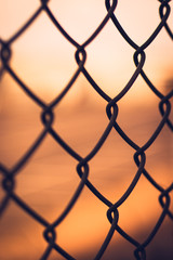 Fototapeta premium Sunset behind chainlink fence