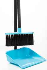 plastic broom in a dustpan for house cleaning isolated on a white background