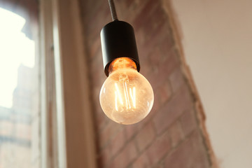  A retro vintage style victorian filament right bulb in a trendy downtown city interior environment. Fashionable addison orange light coffee shop hipster lighting. steampunk inspires lights.