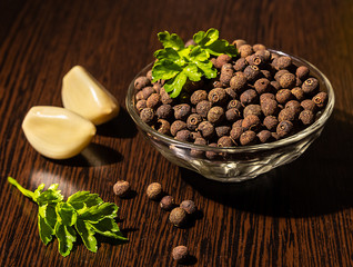 Black pepper peas in a plate, garlic and parsley on the table.