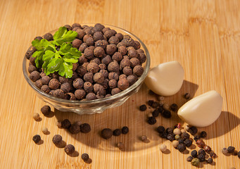 Black pepper peas in a plate, garlic and parsley on the table.
