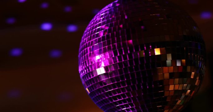 Color 4K handheld footage of a spinning disco ball.