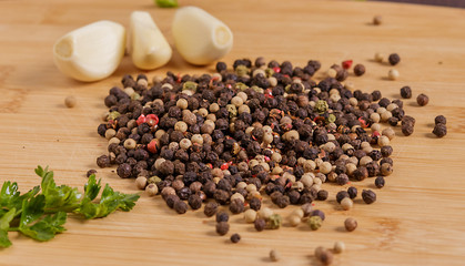 Black pepper, garlic and parsley on the table.