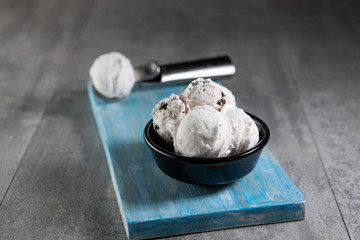 Dairy and stracciatella ice cream in black dessert bowl