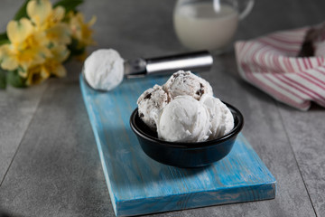 Dairy and stracciatella ice cream in black dessert bowl