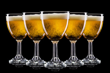 Set of frosty glasses of light beer with foam isolated on a black background - obrazy, fototapety, plakaty