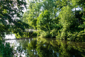 Scenery in the park with a bridge and reflections of trees in the water in Amersfoort, Netherlands
