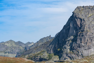 silhouette of mountain range on horizon, rocks and cliffs in mountain valley, tourist trip to mountains