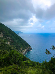 Fototapeta premium Stunning landscape of Mediterranean turquoise sea and green mountains with vineyards visible from the hiking Cinque Terre trail from Vernazza to Monterosso al Mare in Italy.