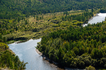 bend of riverbed among green forest, river valley
