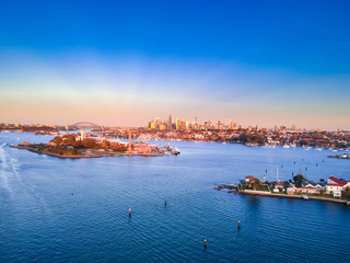 Obraz premium Panoramiczny widok z lotu ptaka drona na port w Sydney przy zachmurzonym zachodzie słońca, pokazujący ładne kolory nabrzeża portu