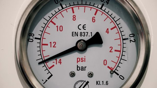 Barometer measuring air pressure in industry. We can see the pressure gauge going up and down - close-up view