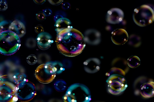 colorful soap bubbles float on the dark, bubbles  abstract background 
