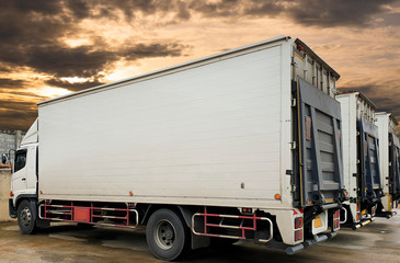 white trucks container with lift door parking at sunset sky, road freight industry delivery logistics and transport.


