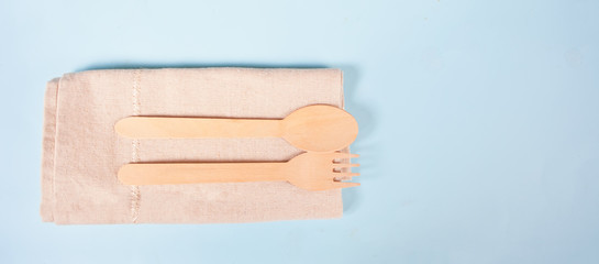 Eco friendly disposable kitchenware utensils cutlery. Wooden fork and spoon on the cotton rag. Ecological concept. Zero waste. Top view. Copy space.