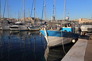 Fototapeta premium Traditional fishing boat and sailboats in the old port of Marseille, France