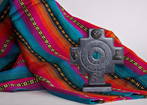 Inca cross chakana and fabric with Inca design patterns