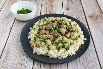 Obraz na płótnie Canvas Chicken with mushrooms and rice with greens with cream sauce