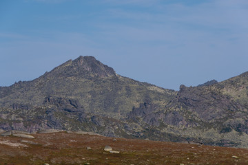 Fototapeta na wymiar silhouette of mountain range on horizon, rocks and cliffs in mountain valley, tourist trip to mountains