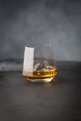 A glass of whiskey on a gray stone background