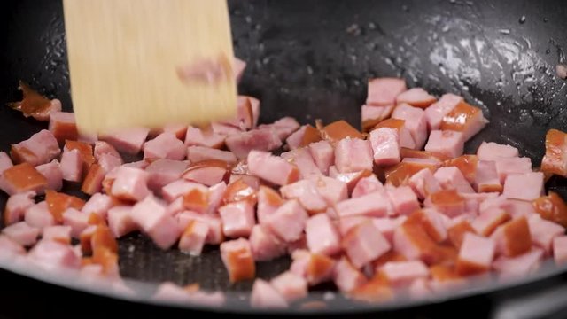 Finely diced meat sausage fried in large pan, stirred occasionaly with wooden spoon
