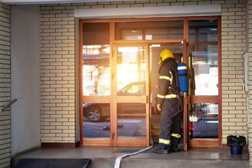 Fireman on the job.Fireman in uniform  at domestic fire in an apartment building.