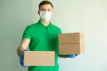 Delivery man employee in green t-shirt uniform face mask gloves hold empty cardboard box isolated on white  background studio Service quarantine pandemic coronavirus virus 2019-ncov concept