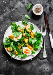 Baked potato, boiled egg and fresh spinach salad on dark background, top view. Delicious breakfast, snack