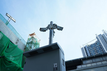Four security cameras in the middle of city near construction site is watching over all direction....
