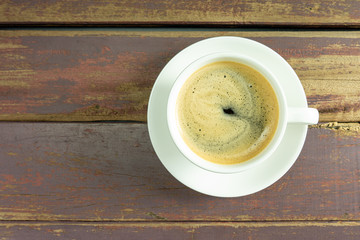 Black coffee cup on brown wood table.