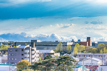 雨上がりの雲がかかった空と地方都市の街並み