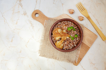 Buckwheat porridge with oyster mushrooms on a light background