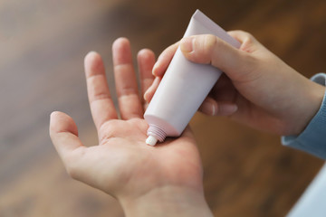 手荒れや乾燥を防ぐためハンドクリームを塗る女性