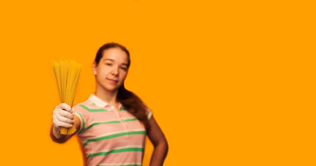 a young girl in a mask and gloves on an orange background with macaroni in her hands. product delivery concept. Funny and with tails, Copyspace for text, banner