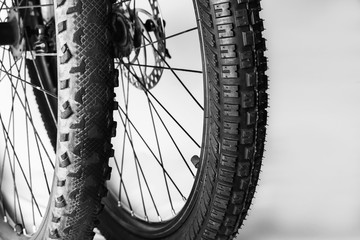 Two wheels from a mountain bike - a new tire on one wheel and an old tire completely worn on the other. Concept of comparison of old and new