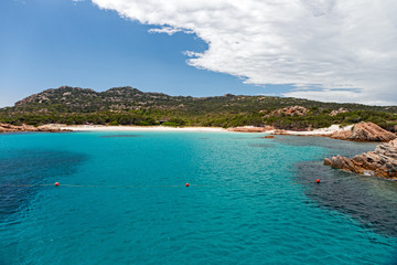 Fototapeta premium Panoramic view of the pink granite rock formations and the clear and transparent waters in the Maddalena archipelago in Sardinia, Italy.