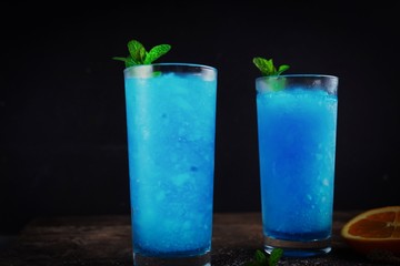 Frozen Blue Lagoon Cocktail against black background, selective focus