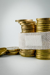 Sick economy. Concept for the economic disaster from the coronavirus pandemic. A band aid (medicated plaster) to fix euro currency coins.