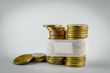 Sick economy. Concept for the economic disaster from the coronavirus pandemic. A band aid (medicated plaster) to fix euro currency coins.